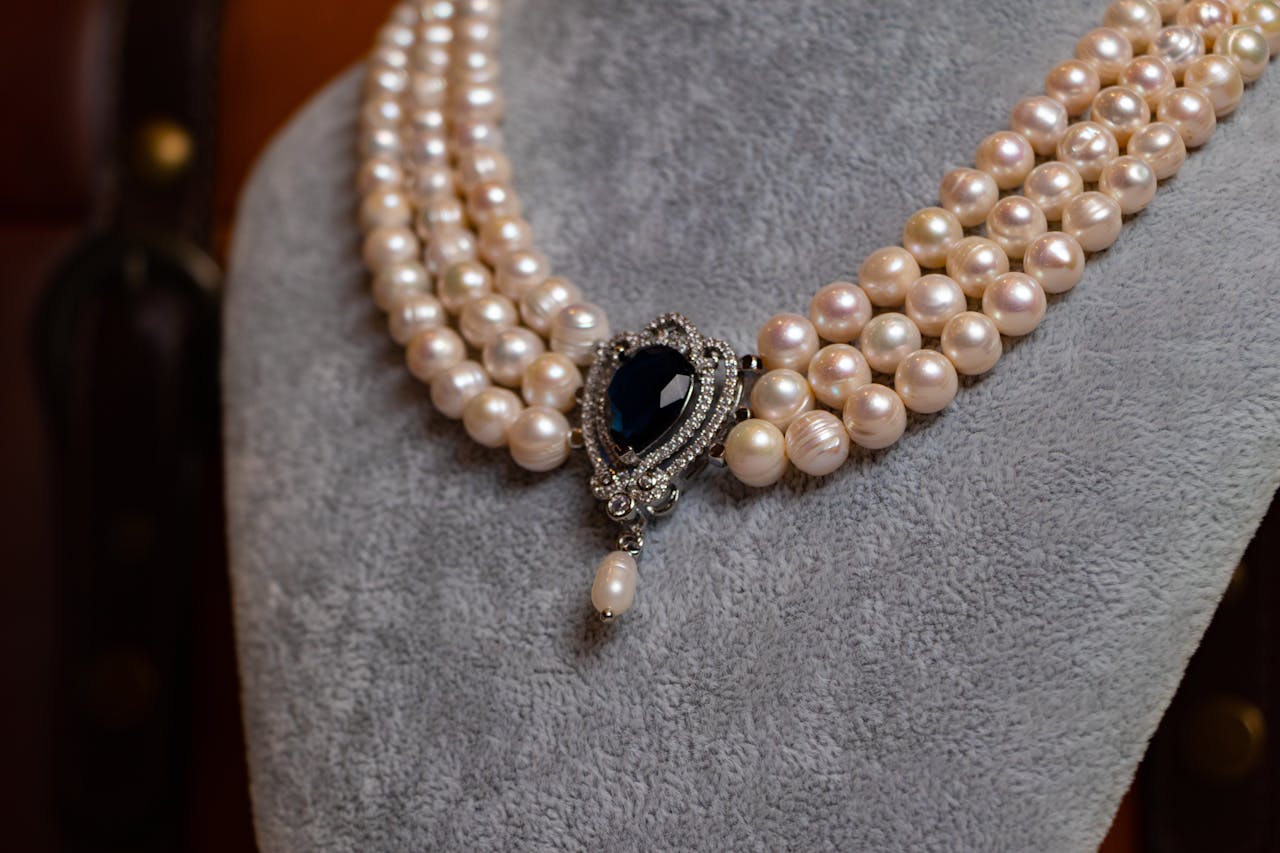 Mastering the First Impression: Your intriguing post title goes here Close-up of a vintage pearl necklace with an ornate sapphire pendant, showcasing luxury and elegance.